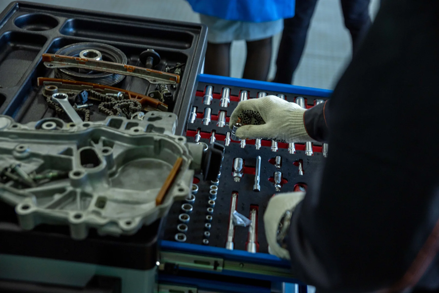 Automotive engine components and workshop tools neatly arranged on a workbench